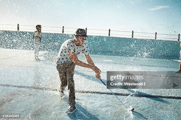 man playing urban golf in empty swimming pool - golf excitement stock pictures, royalty-free photos & images