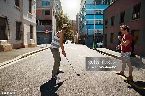 two friends playing urban golf in the city - playing golf stock-fotos und bilder