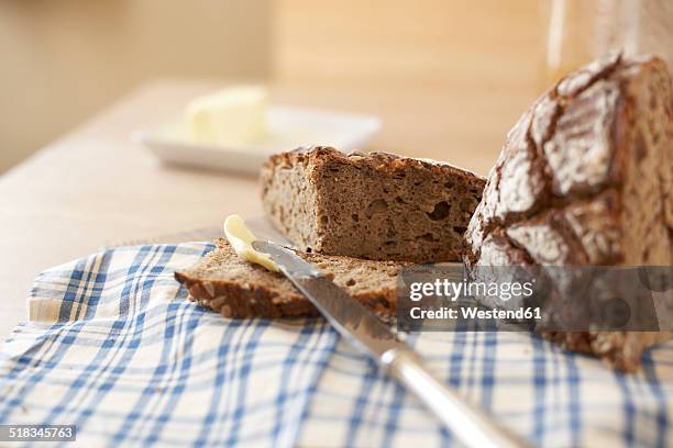buttering slice of wholemeal bread - vollkornbrot stock-fotos und bilder