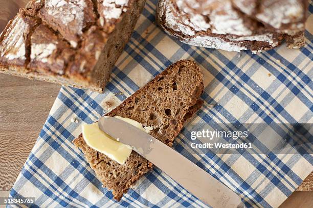 buttering slice of wholemeal bread, elevated view - bread and butter stock pictures, royalty-free photos & images