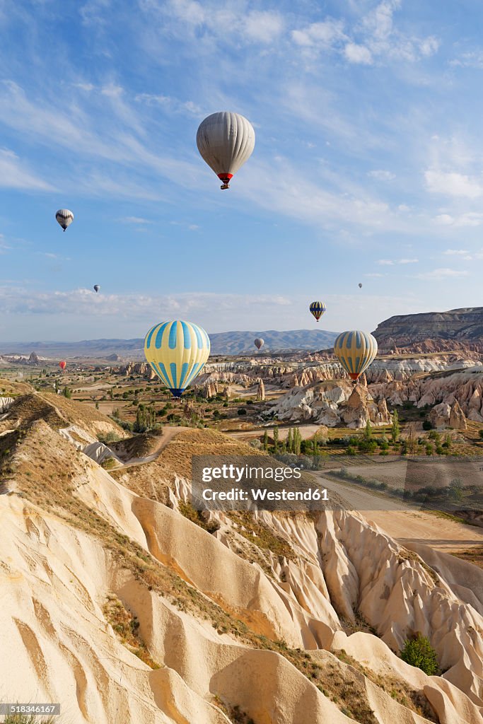 Turkey, Cappadocia, hot air balloons hoovering over tuff rock formations at Goereme National Park