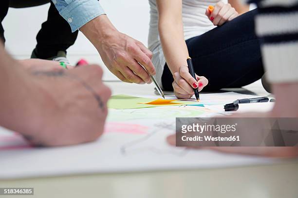 creative professionals drawing on paper - team sketch stock-fotos und bilder