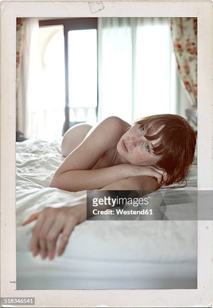 spain, canary islands, pondering young woman lying on hotel bed - nudity foto e immagini stock