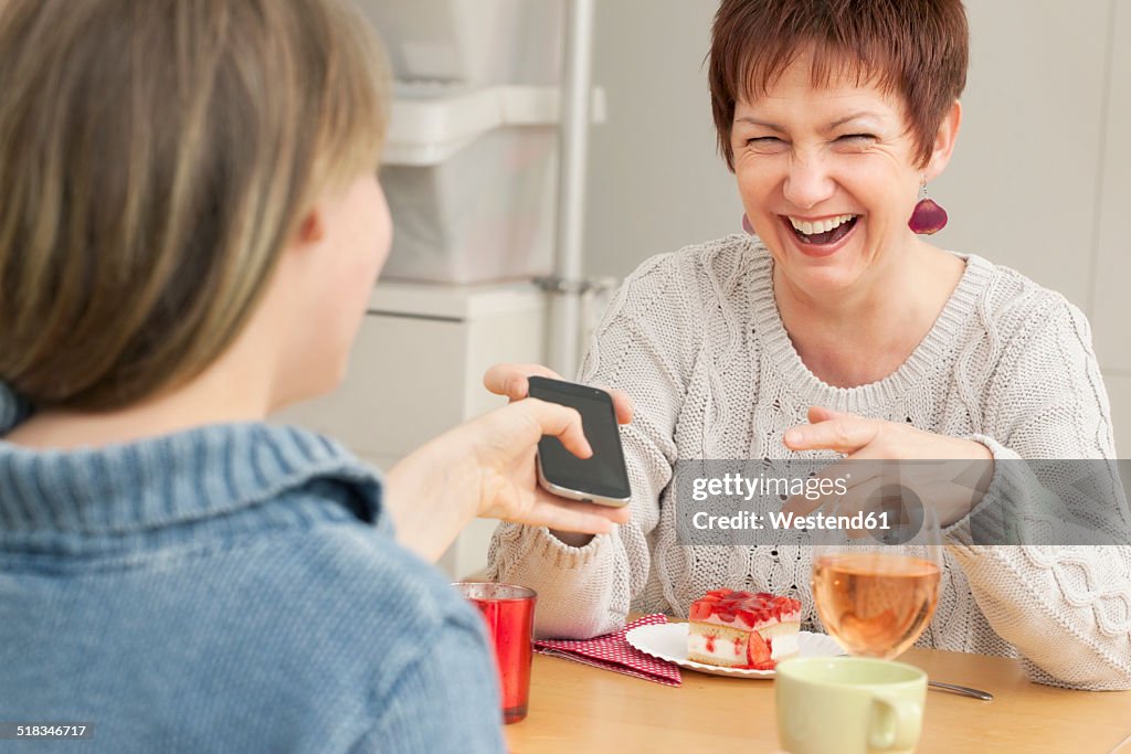 Germany, Berlin, Mother and daughter, using smart phone