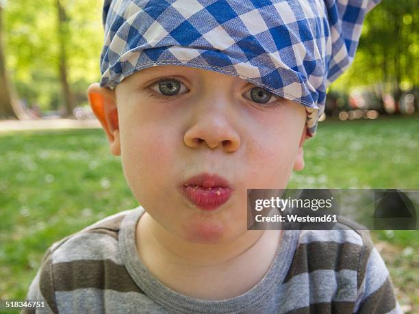 baby boy wearing headscarf eating - mâchonné photos et images de collection