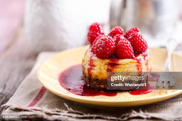 mini cheese cake with raspberries on plate - raspberry coulis stock pictures, royalty-free photos & images