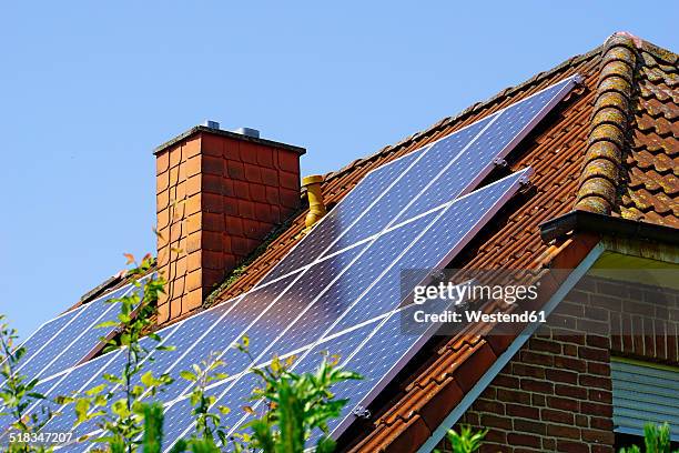 germany, north rhine-westphalia, minden, roof with photovoltaic installation - solar panel stockfoto's en -beelden