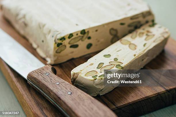 sliced home-made turron with pistachios and almonds on wooden board - nougat stock pictures, royalty-free photos & images