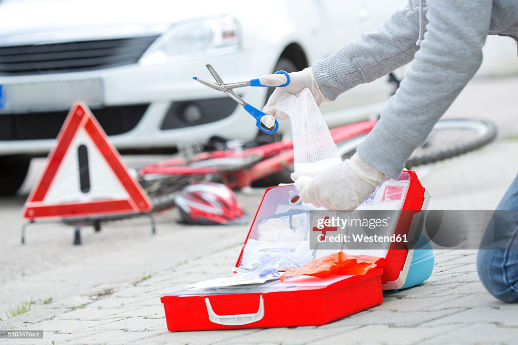 Woman applying first aid at crash scene, partial view