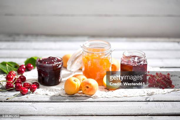 cherry jam and cherries, apricot jam and apricots, currant jam and red currants on dolly - ginja imagens e fotografias de stock