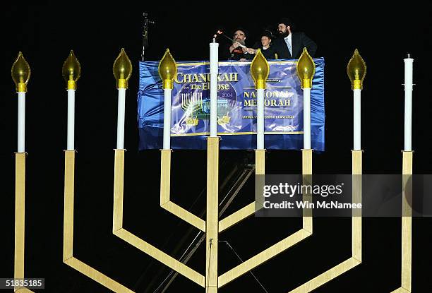 Rabbi Abraham Shemtov, Menachem Felzenberg, and Rabbi Levi Shemtov light the central candle in the National Chanukah Menorah Lighting Ceremony...