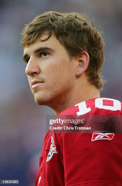 Eli Manning of the New York Giants looks on from the sideline without his helmet against the Philadelphia Eagles during the game at Giants Stadium on...