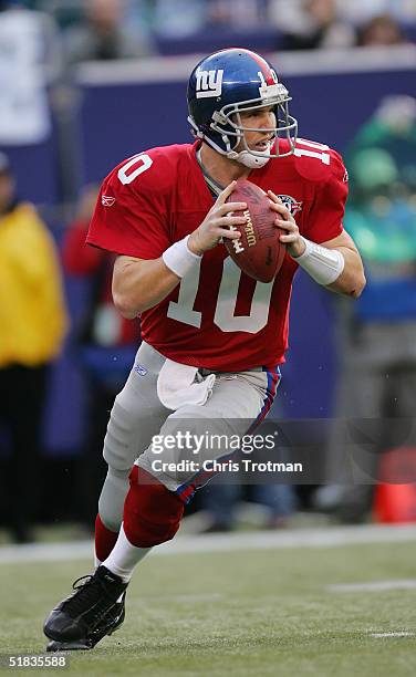 Eli Manning of the New York Giants looks to pass against the Philadelphia Eagles during the game at Giants Stadium on November 28, 2004 in East...