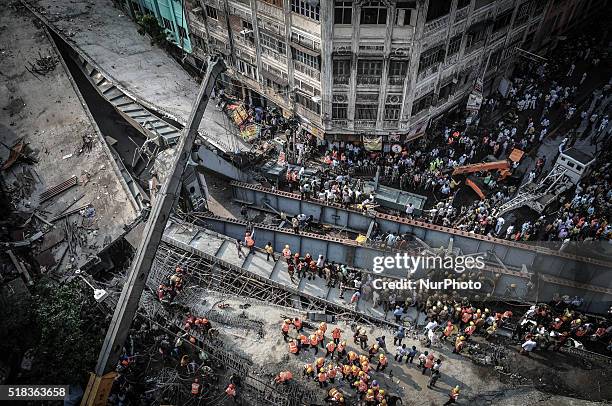 Indian rescue workers and volunteers try to free people trapped under the wreckage of a collapsed fly-over bridge in Kolkata on March 31, 2016. At...