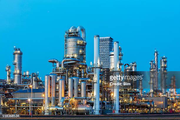 fábrica petroquímica iluminada ao anoitecer - oil refinery - fotografias e filmes do acervo