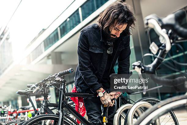 pendler parken seinem fahrrad außerhalb des büros - lock sporting position stock-fotos und bilder
