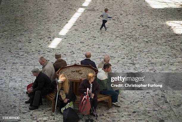 Young boy plays as people rest on a bench in Port Talbot on March 31, 2016 in Port Talbot, Wales. Indian owners Tata Steel has put its British...