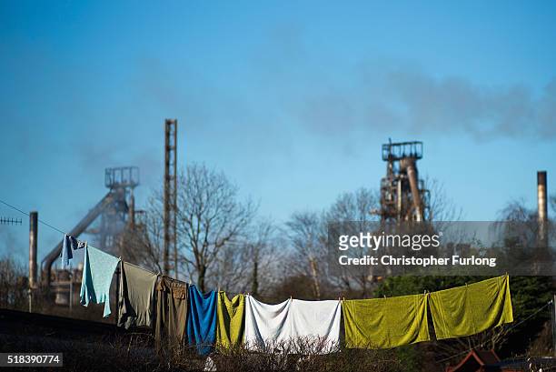 People go about their daily lives as production continues at the Tata Steel plant at Port Talbot on March 31, 2016 in Port Talbot, Wales. Indian...