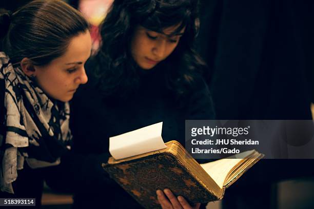 Two college students holding and reading an antique book, 2016. Courtesy Eric Chen. .