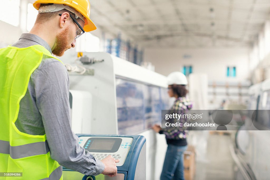 Male worker operating a machine in factory