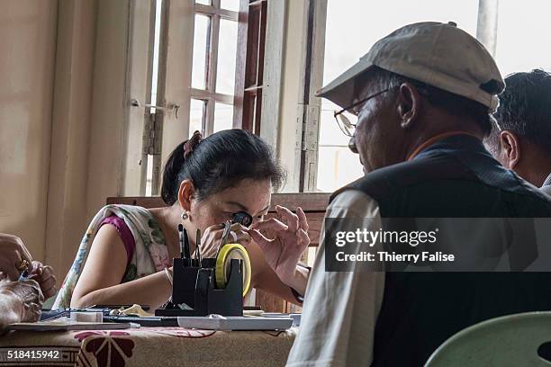 Gem buyer examines stones presented by brokers in a private home.