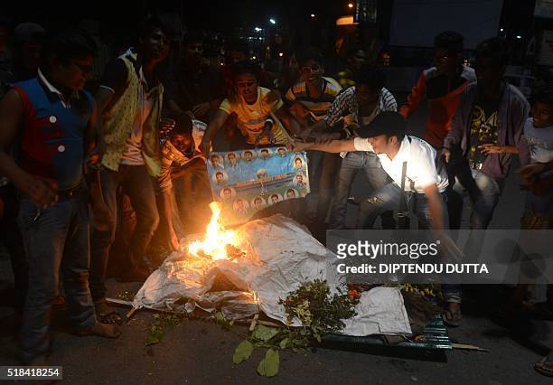Indian cricket fans burn portraits of players as they stage a funeral of the Indian cricket team in the streets of Siliguri on March 31 after India's...