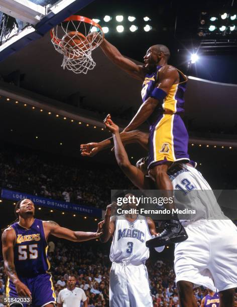 Kobe Bryant of the Los Angeles Lakers makes a dunk against Dwight Howard of the Orlando Magic at TD Waterhouse Centre on November 12, 2004 in...