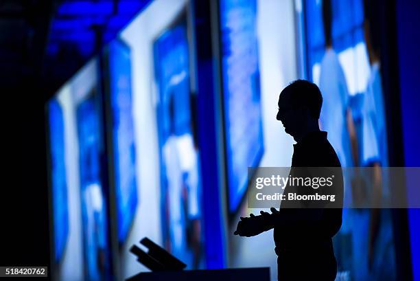 The silhouette of Scott Guthrie, executive vice president of the cloud and enterprise group at Microsoft Corp., is seen as he watches a presentation...