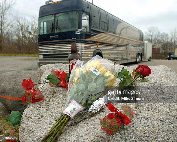 The Damageplan tour bus drives past a makeshift memorial outside of the Alrosa Villa nightclub the day after a gunman fired on the band Damageplan,...