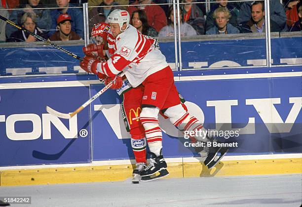 Canadian professional ice hockey player Rob Blake body checks an opponent on the ice during a game on the Ninety-Nine All Stars Tour, December, 1994....