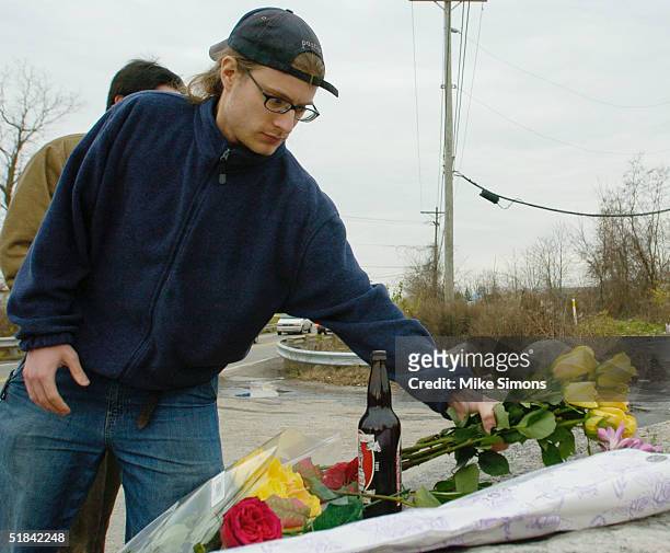 Matt Mitchell places flowers at a makeshift memorial outside the Alrosa Villa nightclub, the day after a gunman fired on the band Damageplan,...