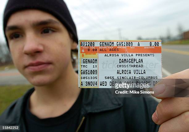 Jeremy Spencer displays his Damageplan concert ticket stub outside the Alrosa Villa nightclub the day after a gunman fired on the band Damageplan,...