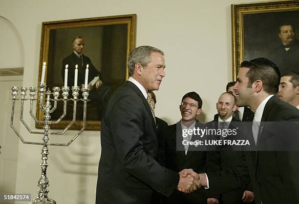 President George W. Bush greets members of the Kol Zimra a cappella choir during a Menorah lighting ceremony before a Hanukkah Reception at the White...