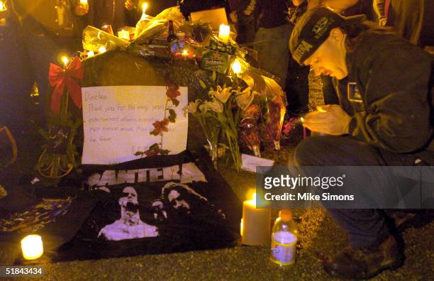 Aaron Holloway lights a candle at a makeshift memorial outside of the Alrosa Villa Club on December 9, 2004 in Columbus, Ohio. According to...