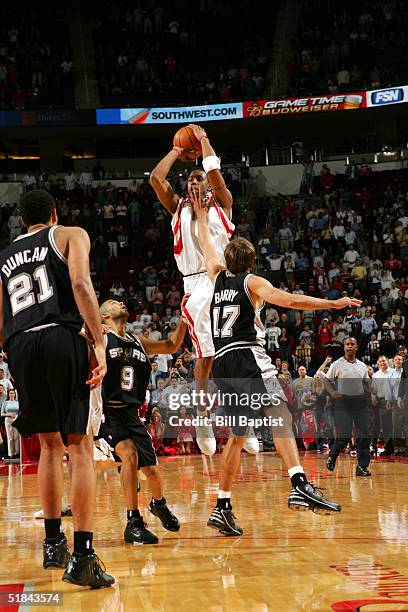 Tracy McGrady of the Houston Rockets shoots the game-winning 3-point shot between Tony Parker and Brent Barry of the San Antonio Spurs on December 9,...