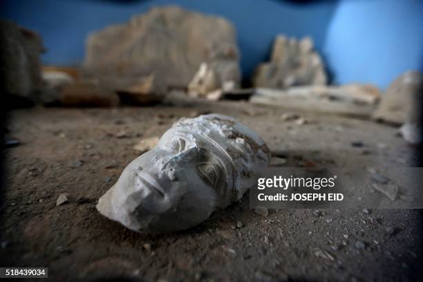 The face of a statue lies on the ground at the destroyed museum in the ancient Syrian city of Palmyra on March 31, 2016. Syrian troops backed by...