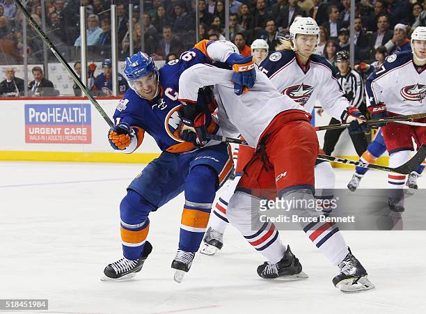 John Tavares of the New York Islanders is held up by Seth Jones of the Columbus Blue Jackets during the second period at the Barclays Center on March...