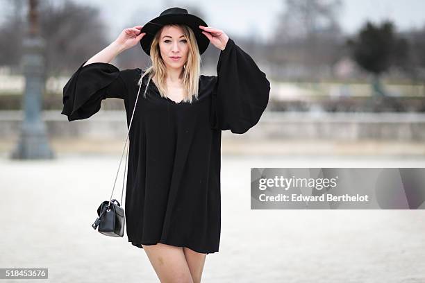 Amelie Lloyd , is wearing a Zara black dress, Forever 21 black boots, a Furla black bag, and a vintage black hat, during a street style session, in...