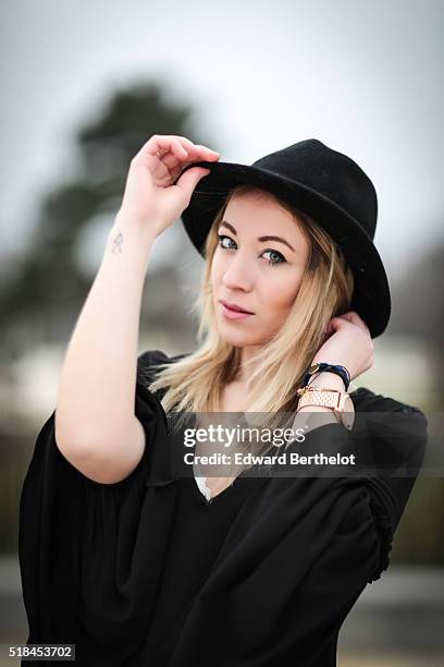 Amelie Lloyd , is wearing a Zara black dress, Forever 21 black boots, a Furla black bag, and a vintage black hat, during a street style session, in...