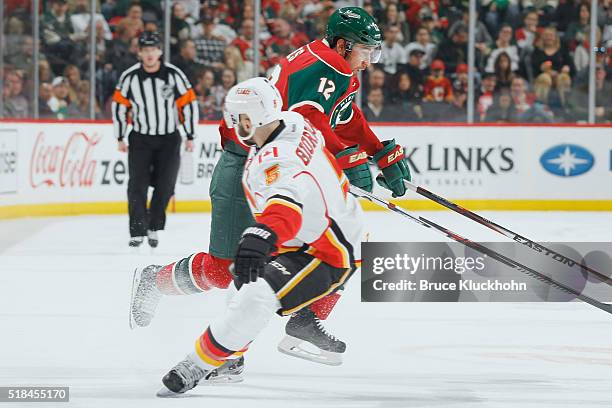 Mark Giordano of the Calgary Flames defends David Jones of the Minnesota Wild during the game on March 24, 2016 at the Xcel Energy Center in St....