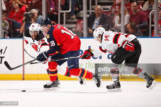 Reilly Smith of the Florida Panthers tangles with teammates Adam Henrique and Stefan Matteau of the New Jersey Devilsat the BB&T Center on March 31,...