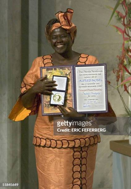 Kenyan tree planter and 2004 Nobel peace prize laureate Wangari Maathai shows 10 December 2004 the award she received in Oslo. AFP PHOTO / ERIC...