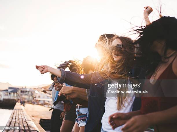 teenager hipster style friends dancing on the pier at sunset - party on the pier stock pictures, royalty-free photos & images