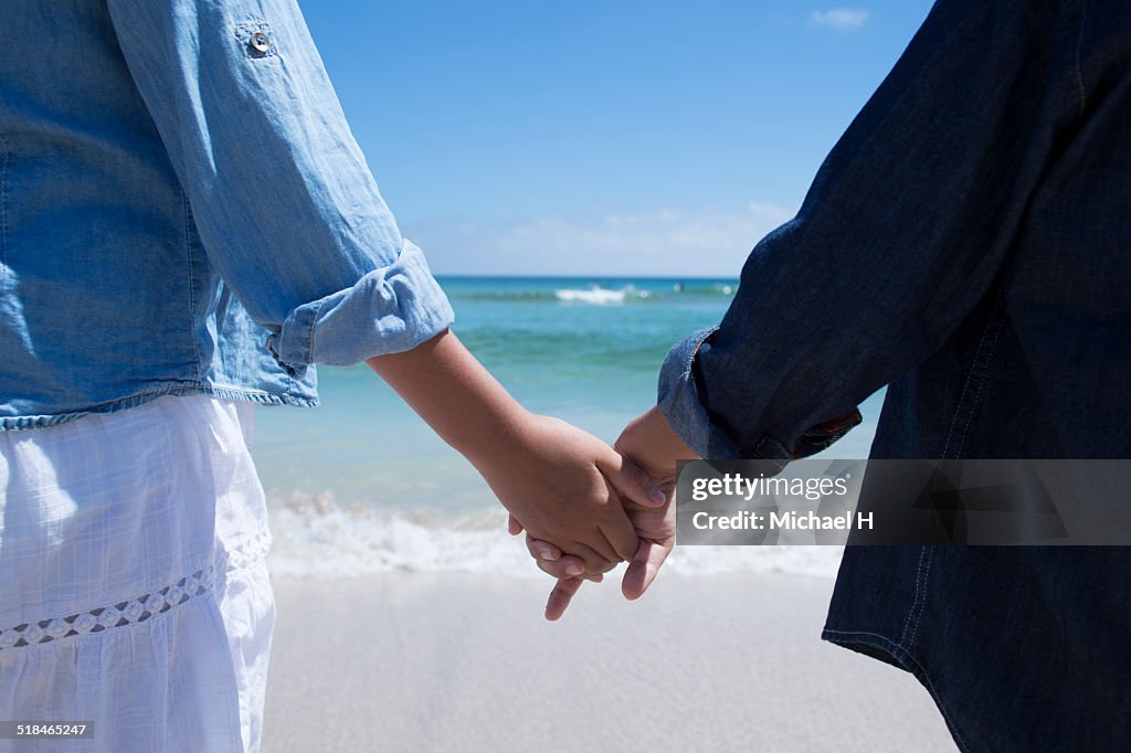Close up of a sister and brother holding hands