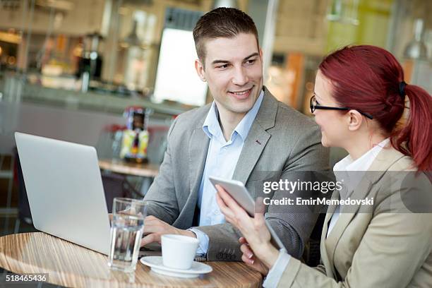 lächelnd geschäftsmann sprechen, um seine weiblichen kollegen in einem café. - male maldives stock-fotos und bilder