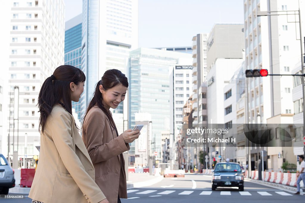 Two businesspeople outdoors walking in office town