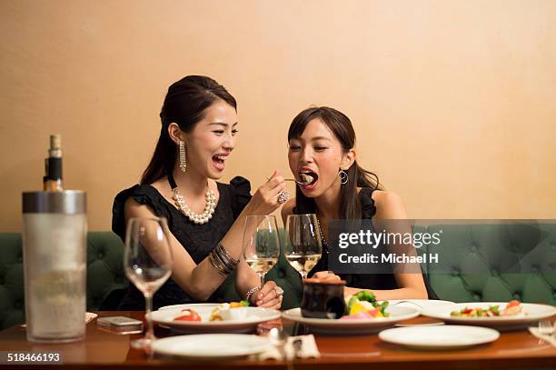 two girls having fun in party atmosphere - asian spoon feeding stock pictures, royalty-free photos & images