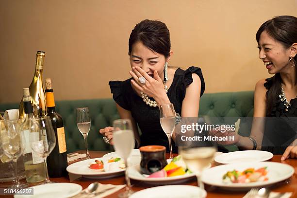 two girls having fun in party atmosphere. - japanese restaurant foto e immagini stock