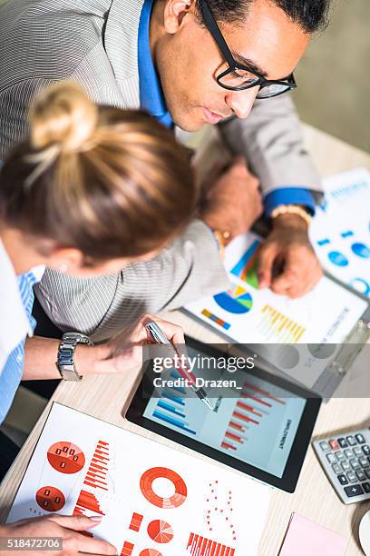 erfolgreiche junge unternehmer analysieren lager markt daten im büro - analysieren zusammenarbeit stock-fotos und bilder