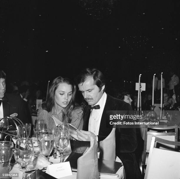 American actor Jack Nicholson and American singer and actress Michelle Phillips look at the menu at their banquet table at the 28th Annual Golden...